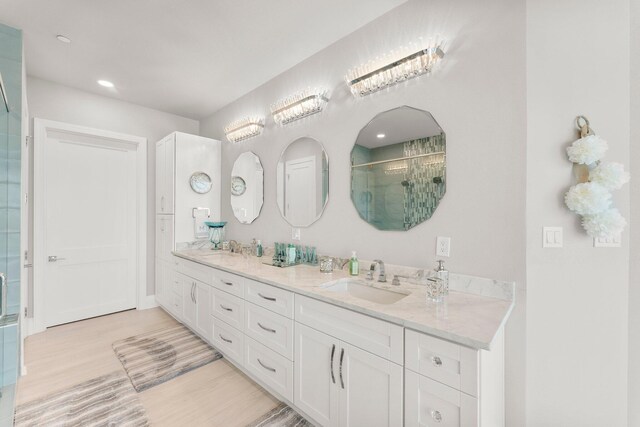 320 Harbor Blvd Unit 1201, Destin, FL 32541 - full bathroom with double vanity, a sink, wood finished floors, and a stall shower
