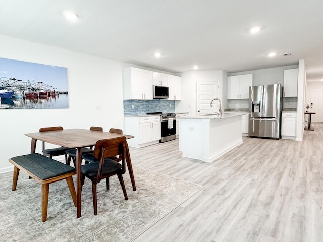 58 Eunola Ln, Freeport, FL 32439 - kitchen with recessed lighting, a kitchen island with sink, stainless steel appliances, light wood-style floors, and visible vents