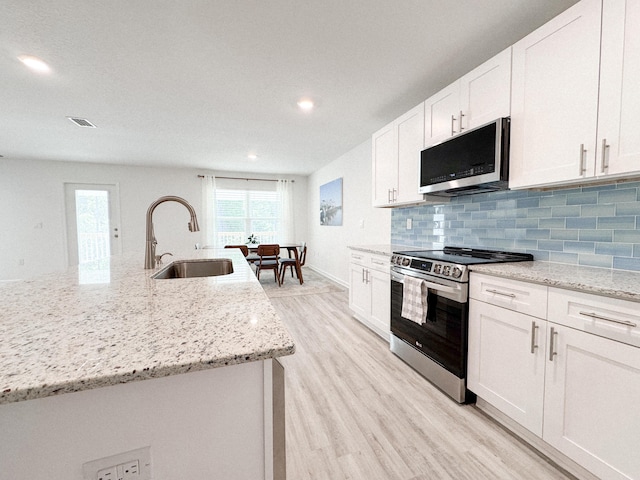 58 Eunola Ln, Freeport, FL 32439 - kitchen featuring white cabinets, a sink, appliances with stainless steel finishes, visible vents, and light wood finished floors