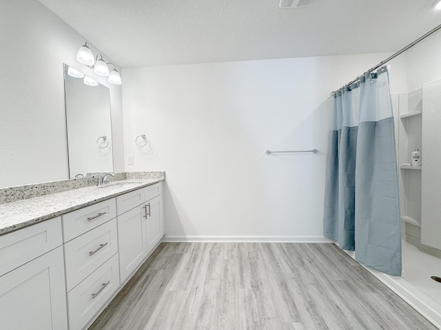 58 Eunola Ln, Freeport, FL 32439 - full bath featuring a textured ceiling, wood finished floors, vanity, and curtained shower