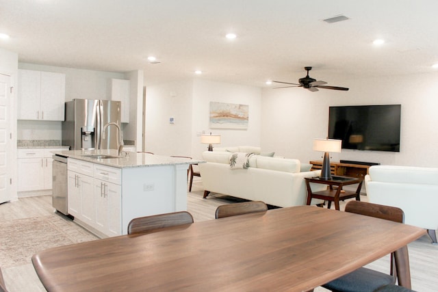 58 Eunola Ln, Freeport, FL 32439 - interior space featuring white cabinets, a sink, visible vents, stainless steel appliances, and an island with sink