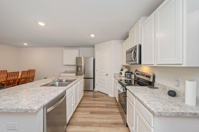 6629 Spyglass Hill Rd, Laurel Hill, FL 32567 - kitchen with an island with sink, white cabinets, a sink, light wood finished floors, and stainless steel appliances