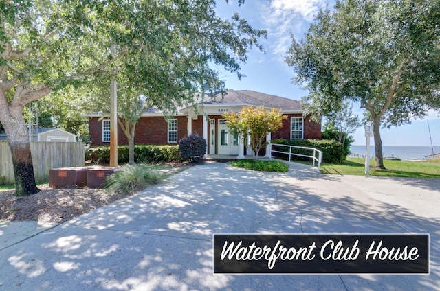 9124 Orlando Ave, Navarre, FL 32566 - view of front of home featuring fence, brick siding, and a water view