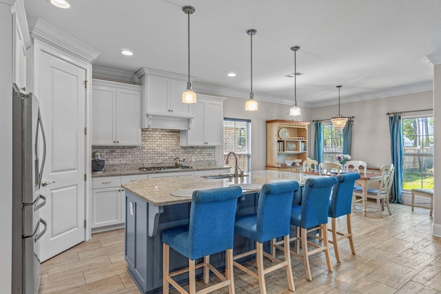 9124 Orlando Ave, Navarre, FL 32566 - kitchen featuring a sink, appliances with stainless steel finishes, white cabinetry, tasteful backsplash, and light stone countertops