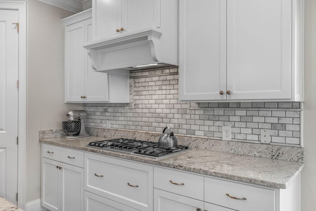 9124 Orlando Ave, Navarre, FL 32566 - kitchen featuring stainless steel gas cooktop, white cabinets, premium range hood, decorative backsplash, and crown molding