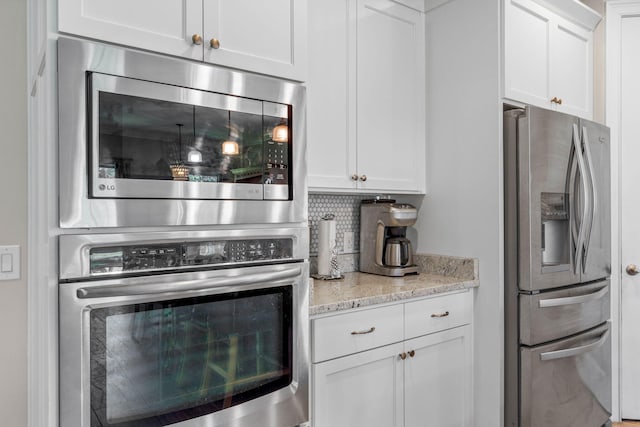 9124 Orlando Ave, Navarre, FL 32566 - kitchen with appliances with stainless steel finishes, tasteful backsplash, white cabinets, and light stone counters