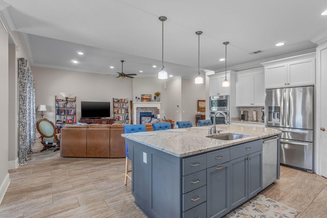 9124 Orlando Ave, Navarre, FL 32566 - kitchen featuring stainless steel appliances, a sink, white cabinets, a ceiling fan, and ornamental molding