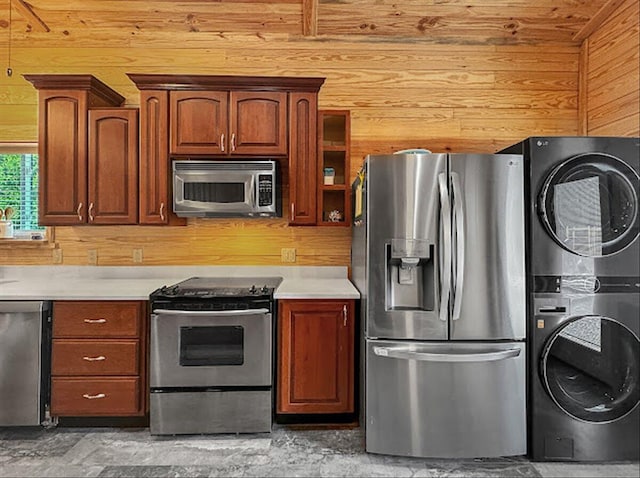 178 Osage Dr, Defuniak Springs, FL 32433 - kitchen with light countertops, open shelves, wooden walls, stacked washing maching and dryer, and appliances with stainless steel finishes