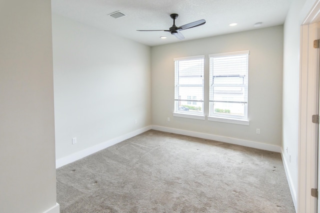 spare room with carpet floors, visible vents, baseboards, and ceiling fan
