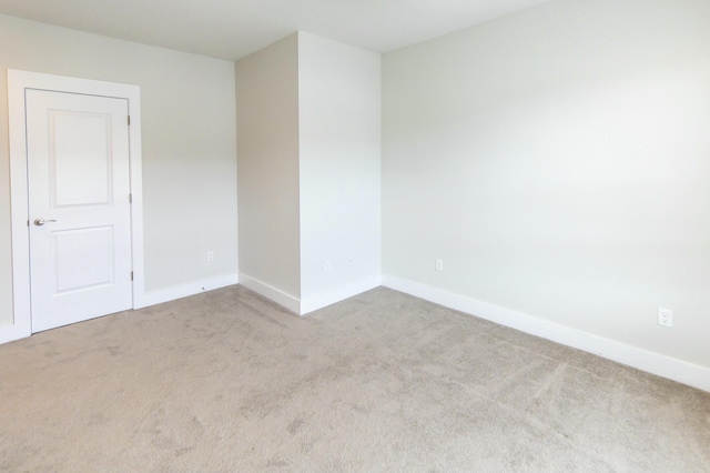 empty room with baseboards and light carpet