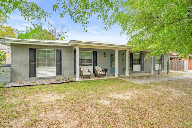 1017 Revere Dr, Pensacola, FL 32505 - ranch-style house with metal roof, fence, a porch, and brick siding