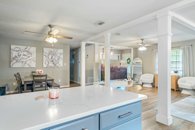 1017 Revere Dr, Pensacola, FL 32505 - kitchen with blue cabinets, decorative columns, visible vents, a ceiling fan, and open floor plan