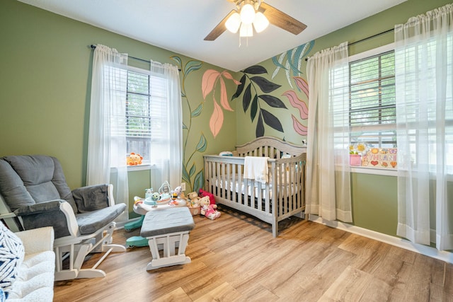 1017 Revere Dr, Pensacola, FL 32505 - bedroom with a crib, ceiling fan, wood finished floors, and baseboards