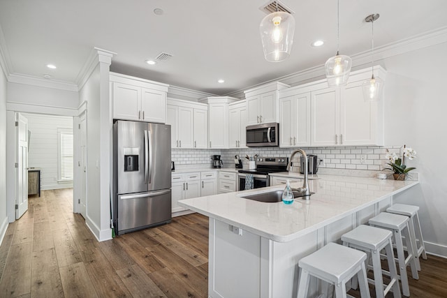 116 Riviera Dr, Panama City Beach, FL 32413 - kitchen with a peninsula, a sink, visible vents, appliances with stainless steel finishes, and ornamental molding