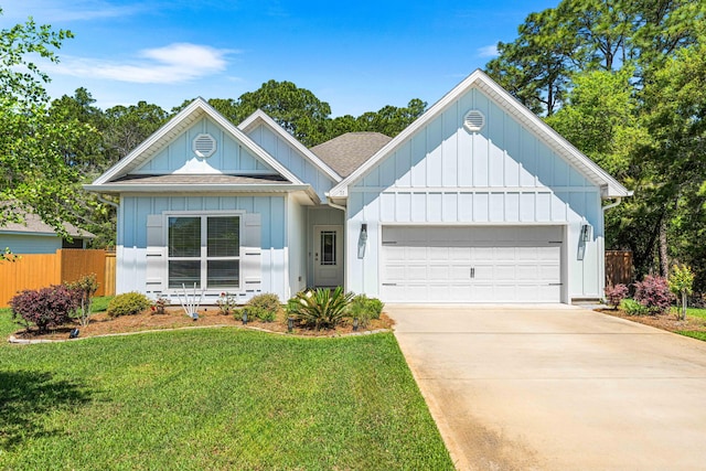 view of front of property with fence, board and batten siding, a front lawn, and a garage