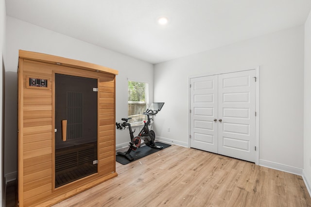 exercise room featuring wood finished floors and baseboards