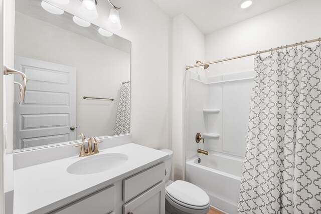 bathroom featuring toilet, recessed lighting, shower / bath combo with shower curtain, and vanity