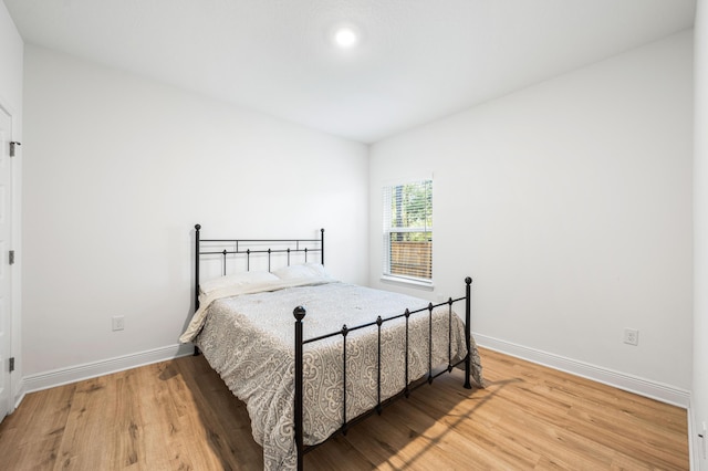 bedroom with baseboards and wood finished floors
