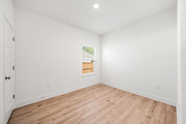 unfurnished room featuring baseboards and light wood finished floors