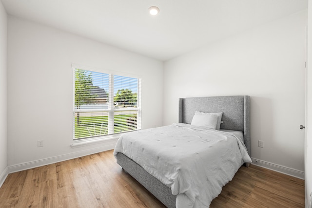 bedroom with wood finished floors and baseboards