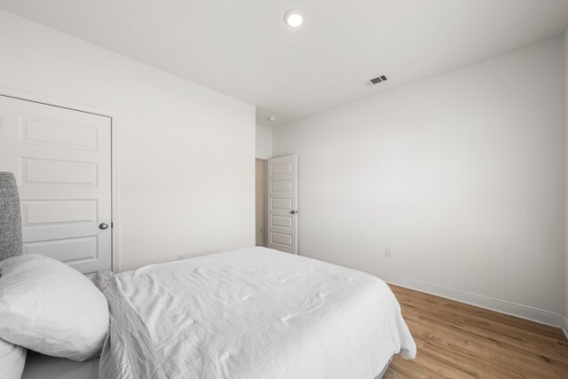 bedroom featuring recessed lighting, visible vents, baseboards, and light wood-type flooring