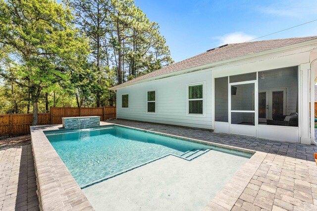 view of swimming pool featuring a fenced in pool, a fenced backyard, a sunroom, and a patio area