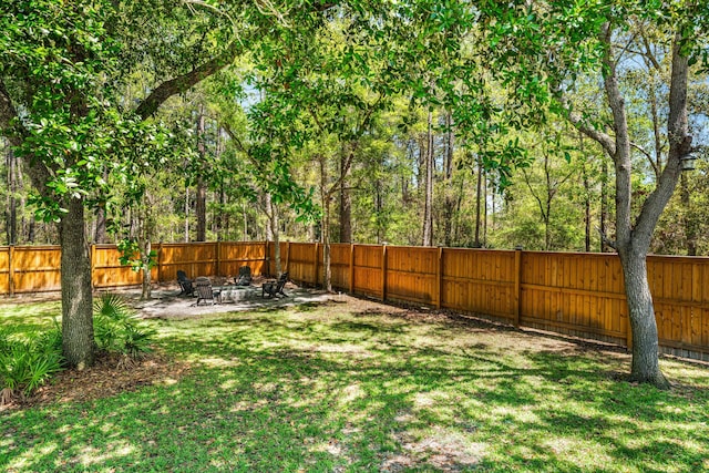 view of yard featuring an outdoor fire pit, a fenced backyard, and a patio area