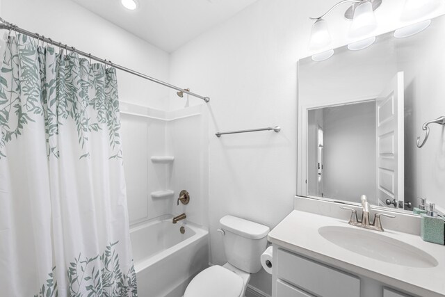 full bathroom featuring recessed lighting, shower / bath combo with shower curtain, toilet, and vanity