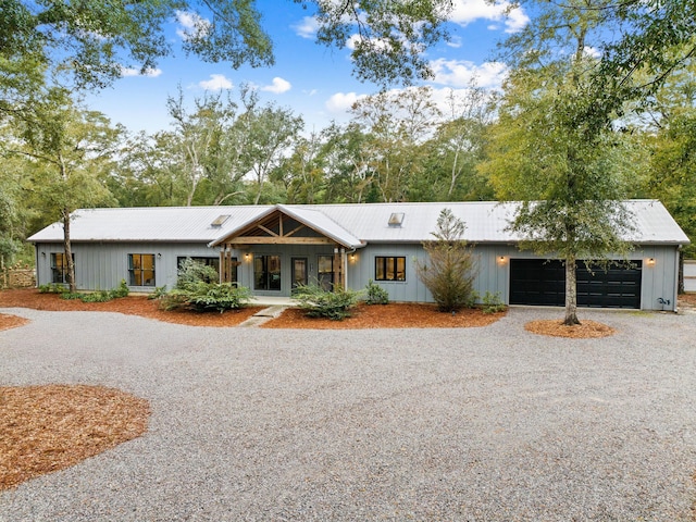 213 Abt Martin Ave, Defuniak Springs, FL 32433 - single story home featuring board and batten siding, driveway, metal roof, and a garage
