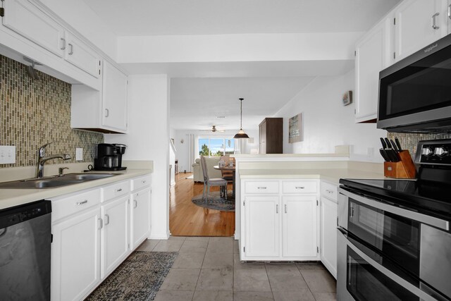 8522 Gulf Blvd Unit 20, Navarre, FL 32566 - kitchen featuring a peninsula, white cabinetry, stainless steel appliances, and a sink