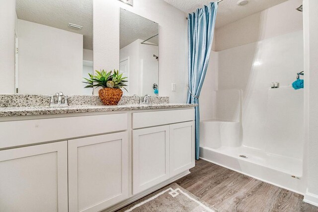 8760 Bluebell St, Milton, FL 32583 - full bath with double vanity, wood finished floors, a sink, and a shower with curtain