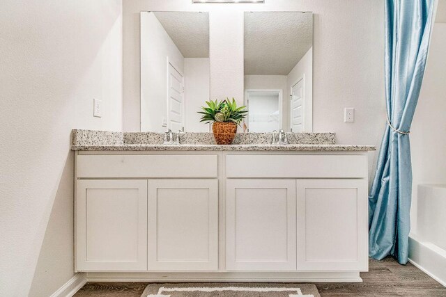 8760 Bluebell St, Milton, FL 32583 - bathroom with double vanity, wood finished floors, and a sink