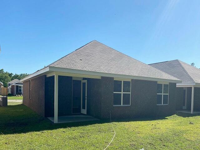 8760 Bluebell St, Milton, FL 32583 - rear view of house with a lawn, a sunroom, and a shingled roof
