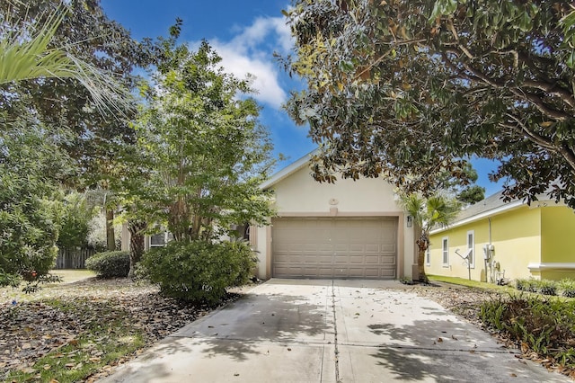 226 Talquin Cv, Destin, FL 32541 - view of property hidden behind natural elements featuring an attached garage, stucco siding, and driveway