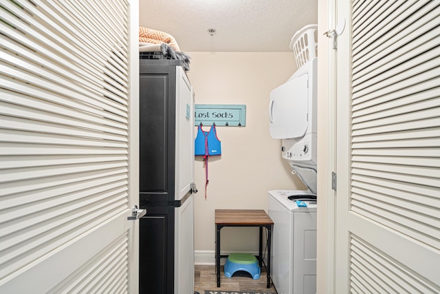 112 Seascape Dr Unit 707, Miramar Beach, FL 32550 - clothes washing area featuring wood finished floors, stacked washer and clothes dryer, and laundry area