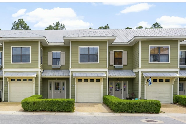multi unit property featuring metal roof and a garage