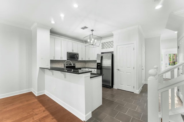 kitchen featuring stainless steel appliances, visible vents, a peninsula, white cabinetry, and dark countertops