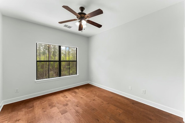 spare room featuring baseboards, visible vents, a ceiling fan, and hardwood / wood-style floors