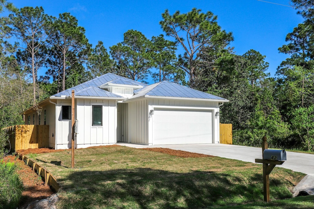 ranch-style house featuring board and batten siding, a front yard, a garage, fence, and concrete driveway