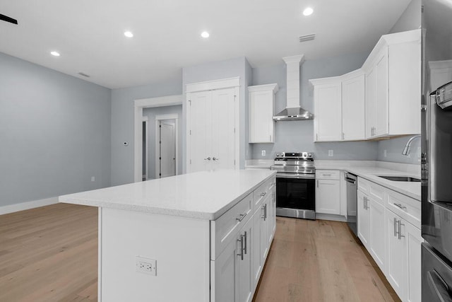 42 Central 8th St, Santa Rosa Beach, FL 32459 - kitchen with light wood-style floors, a center island, wall chimney range hood, and stainless steel appliances