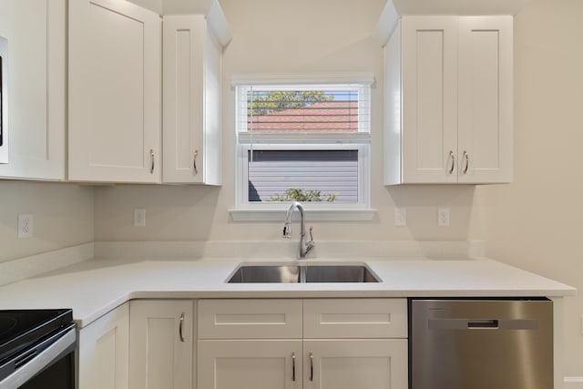 kitchen with white cabinetry, stainless steel dishwasher, light countertops, and a sink