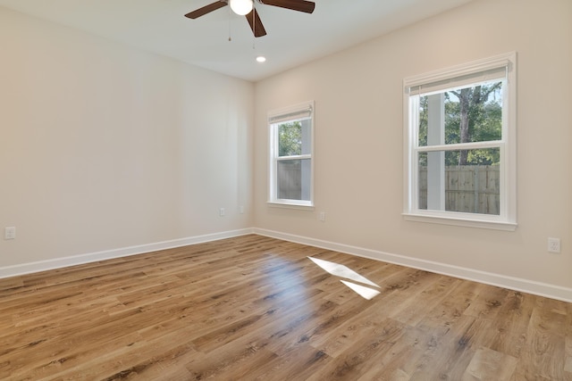 empty room featuring wood finished floors, a ceiling fan, recessed lighting, and baseboards