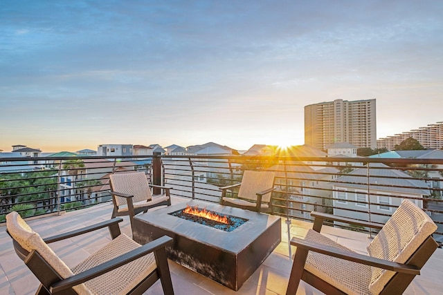 balcony at dusk featuring a fire pit