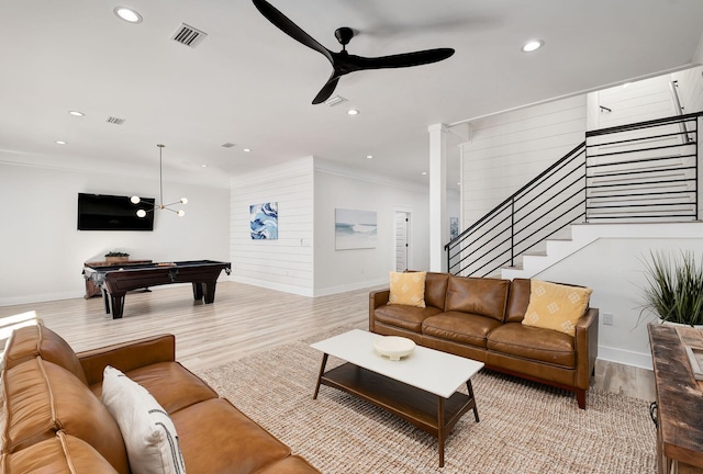 living room with baseboards, ceiling fan, crown molding, wood finished floors, and stairway