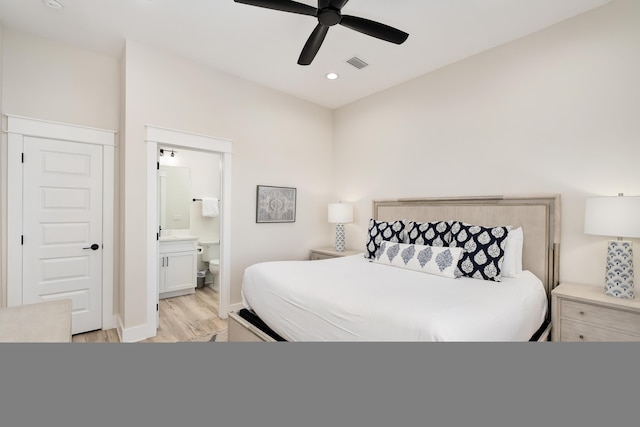 bedroom with light wood-style flooring, recessed lighting, ensuite bath, a ceiling fan, and baseboards