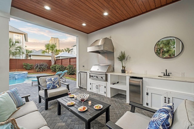 view of patio / terrace featuring a grill, exterior kitchen, fence, outdoor lounge area, and a sink
