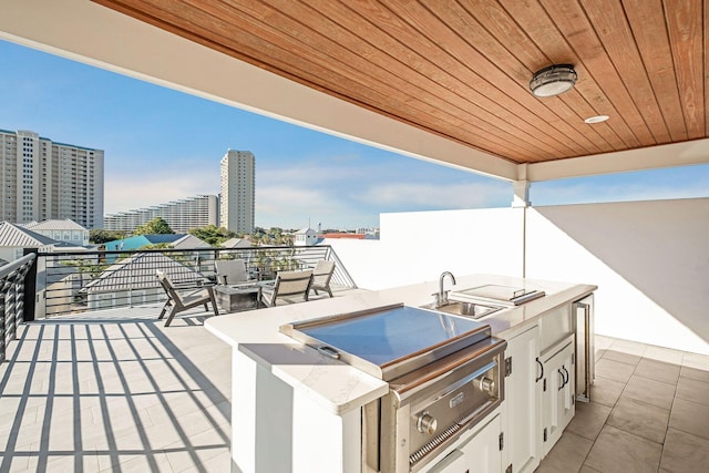 view of patio / terrace featuring a sink, an outdoor kitchen, area for grilling, and a view of city