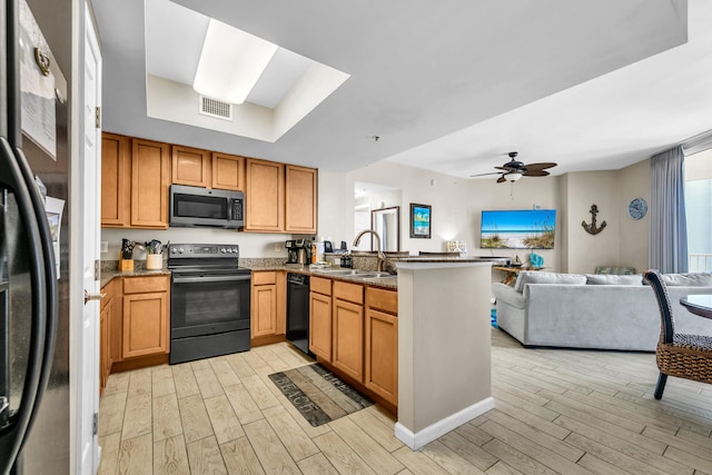 4207 Indian Bayou Trl Unit 2501, Destin, FL 32541 - kitchen featuring a sink, a peninsula, light wood-type flooring, visible vents, and black appliances
