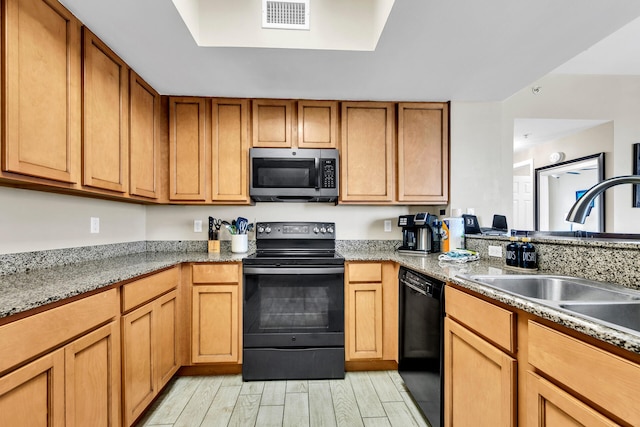 4207 Indian Bayou Trl Unit 2501, Destin, FL 32541 - kitchen featuring visible vents, light stone counters, a sink, light wood finished floors, and black appliances