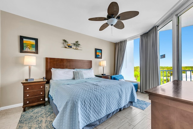 4207 Indian Bayou Trl Unit 2501, Destin, FL 32541 - bedroom featuring baseboards, ceiling fan, a wall of windows, and wood finished floors